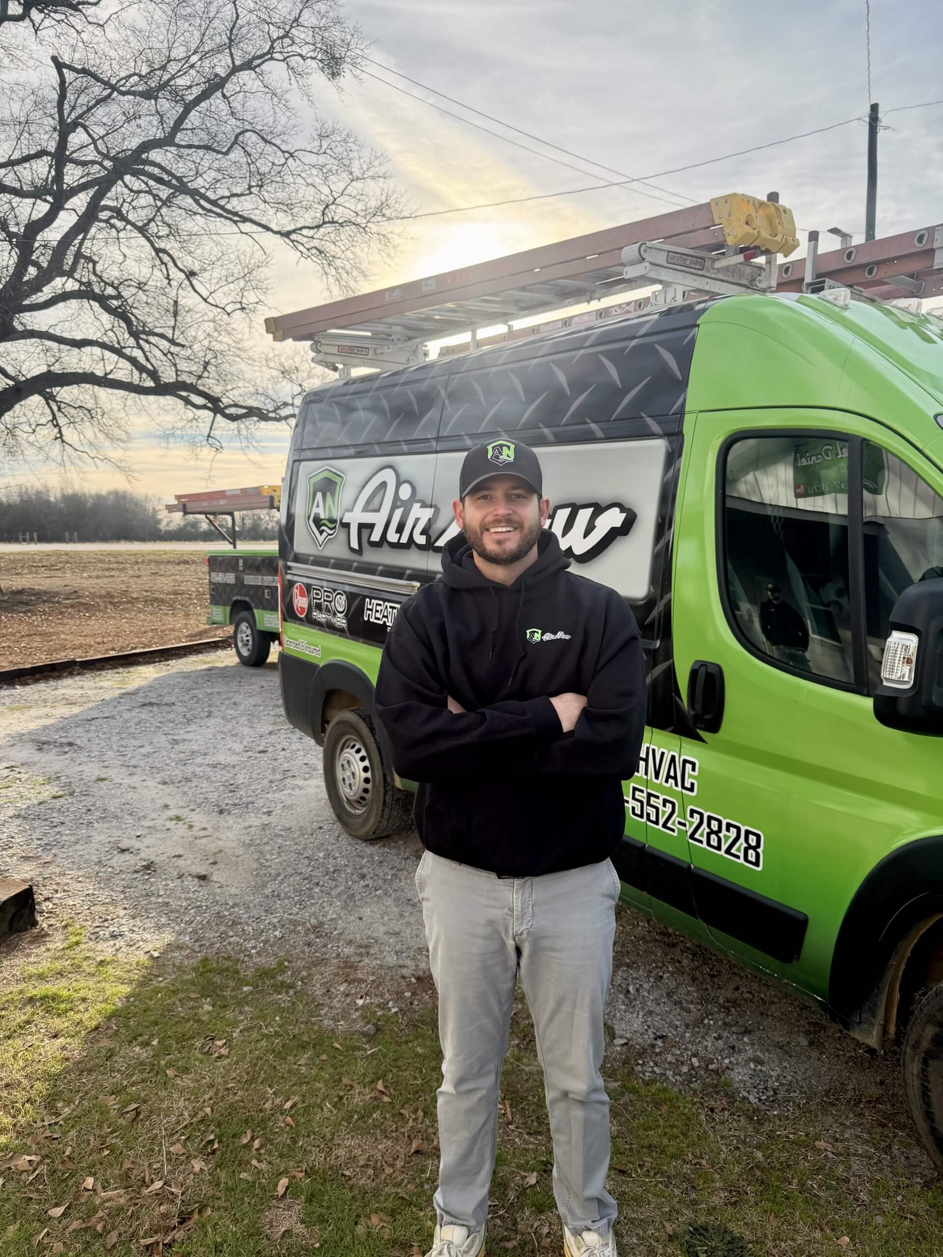 An AirNow technician smiling proudly with his truck in Augusta